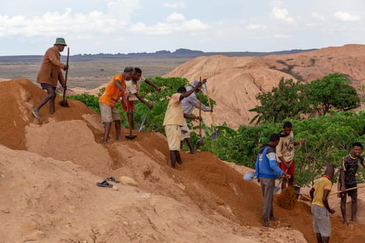 Ilakaka, Madagascar - November 24th 2022 - Working in tandem, miners united their effort, shoveling earth and meticulously seeking out sapphire gems, synchronized effort reminiscent of linked chains.