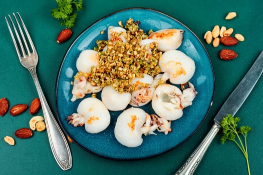 Baked young squids served with nut salad. BBQ.