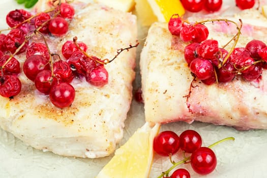 Cod fillet without skin baked with red currants. Cod fish, space for text.