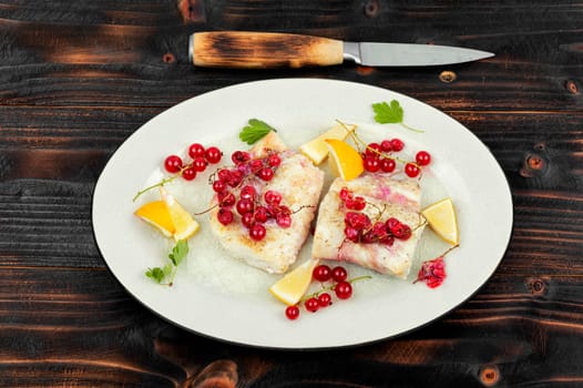 Cod fillet without skin baked with red currants. Cod fish, space for text.