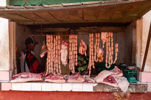 Mandoto, Madagascar - November 9th, 2022: The shop displays sausages on a stand that hang in the heat of the day.