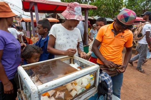 Mandoto, Madagascar - November 2nd 2022: Malagasy man sell milk product from simple cooling case on the street of Mandoto.
