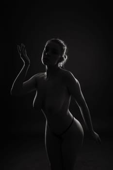 Photo of a gentle seductive topless plump lady isolated on black background