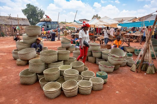 Mandoto, Madagascar - November 9th, 2022: Sale of wicker basket in street market in Mandoto city, with vendors and ordinary people shopping and socializing.