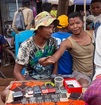 Mandoto, Madagascar - November 2nd 2022: Malagasy man sell old fashioned cellular mobile phones on the street of Mandoto.