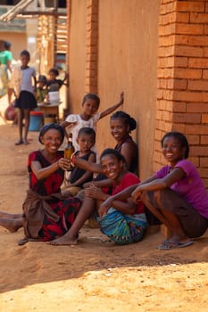 Vohitsaoka, Madagascar - November 17, 2022: Local woman drinking beer on the street at noon.
