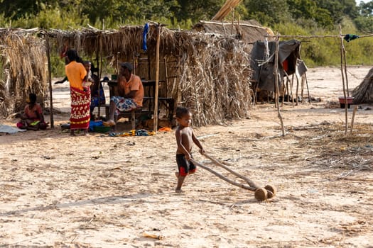 Ferry port Bekopaka, Madagascar - NOVEMBER 4 2022: Boy have fun with a simple toy on wheels at the ferry port in Bekopaka.