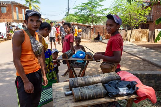 Miandrivazo, Madagascar - November 2nd 2022: Street vendors selling "koba,"" a traditional Malagasy sweet made from ground peanuts, brown sugar, and rice flour, reflecting the local culinary heritage."