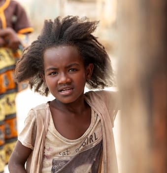 Bekopaka - Antsalova, Madagascar- November 6. 2022: Small cute Malagasy girl with long hair , happy little dancer on celebration in village Bekopaka, region Melaky, Madagascar.