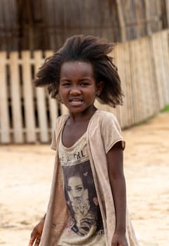 Bekopaka - Antsalova, Madagascar- November 6. 2022: Small cute Malagasy girl with long hair , happy little dancer on celebration in village Bekopaka, region Melaky, Madagascar.