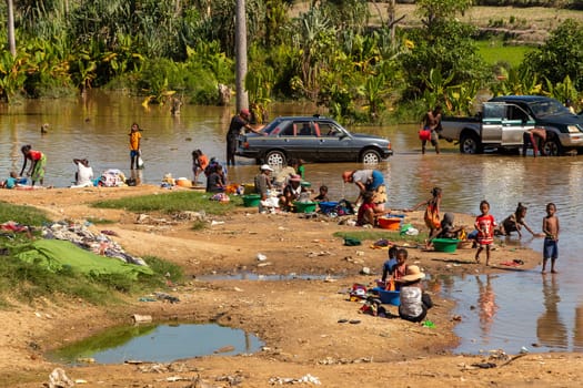 20.11.2022, Ialakaka, Madagascar - life-giving river in Ilakaka, local people bathing, washing, cleaning their cars