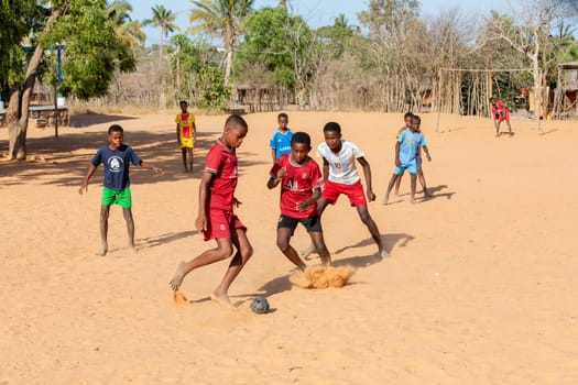 Kivalo, Madagascar - November 8th 2022: Children from Kivalo village playing soccer with a handmade textile ball behind their school.
