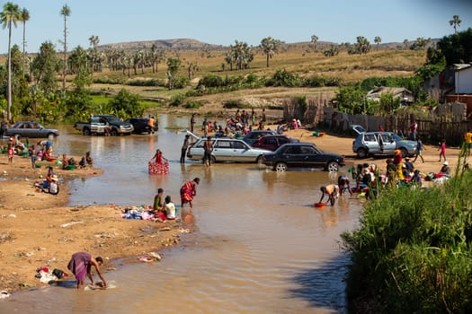 20.11.2022, Ialakaka, Madagascar - life-giving river in Ilakaka, local people bathing, washing, cleaning their cars