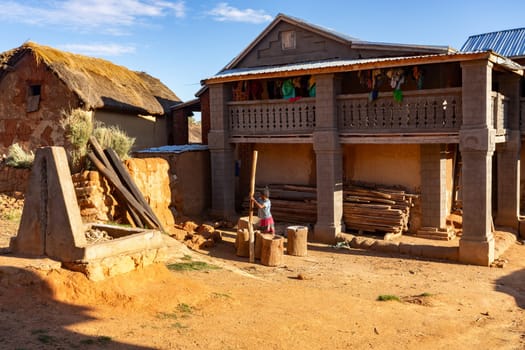 Andringitra Mountains, Madagascar - November 15, 2022: A young Malagasy woman living in the Andringitra Mountains prepares flour with primitive tools in a mortar.