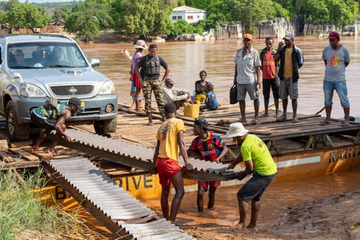 Andadoany - Bekopaka, Madagascar - November 4th, 2022: A ferry carrying passengers and cars travels on the port Tsiribihina on River Mania in Madagascar.