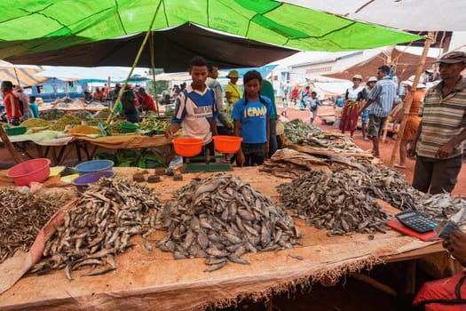 Mandoto, Madagascar - November 9. 2022 - Malagasy man buys dried fish at a street market. Fishing is one of the livelihoods in Madagascar.