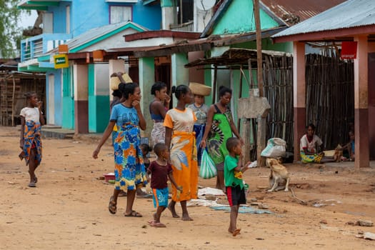 Bekopaka, Madagascar - November 6, 2022: Malagasy woman's with children walking down the street.