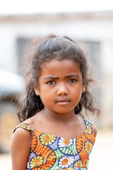 Bekopaka - Antsalova, Madagascar- November 6. 2022: Small cute Malagasy girl with long hair , happy little dancer on celebration in village Bekopaka, region Melaky, Madagascar.