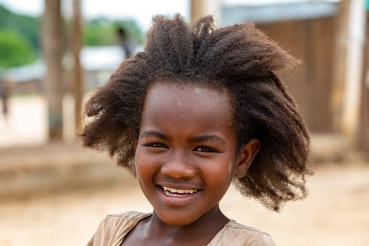 Bekopaka - Antsalova, Madagascar- November 6. 2022: Small cute Malagasy girl with long hair , happy little dancer on celebration in village Bekopaka, region Melaky, Madagascar.