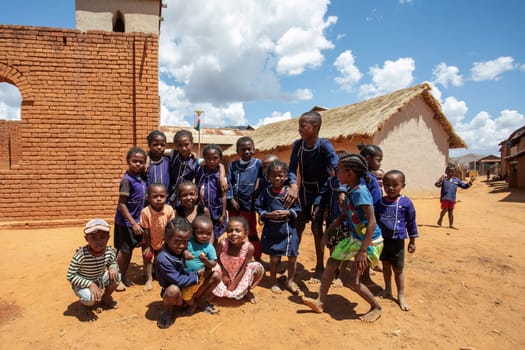 Vohitsaoka, Ambalavao, Madagascar - November 17. 2022: Group of happy Malagasy school children students in front of school. School attendance is compulsory, but many children do not go to school.