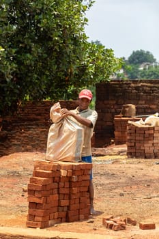 Mandoto, Madagascar - November 9th 2022: Street vendor selling handmade building bricks. This is a common sight in this region, as many people make their own bricks to save money.