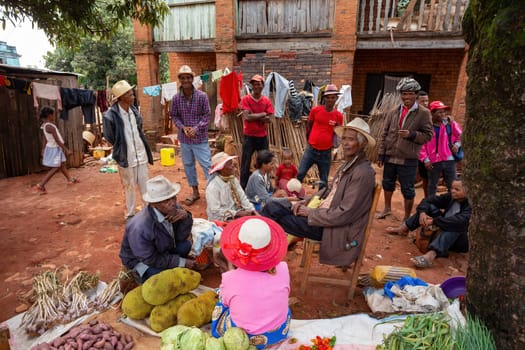 Mandoto, Madagascar - November 9th, 2022: Street in Mandoto city, with vendors and ordinary people shopping and socializing. Woman sell fruit like jackfruit, cabbage, garlic and potatoes.