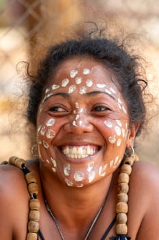 Miandrivazo, Madagascar - November 2nd 2022 - Close up portrait of a Malagasy woman with white dots painted on her face as part of a traditional culture.