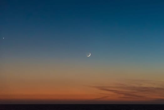 Crescent moon scenic above the last sunlight of the day