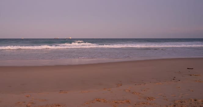 Scenic view from Warana Beach, Kawana, Queensland's Sunshine Coast as a bluemoon full moon rises above the horizon at dusk.