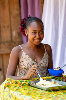 02.11.2022 - Miandrivazo, Madagascar: Local woman savors a traditional Malagasy meal at a street stall