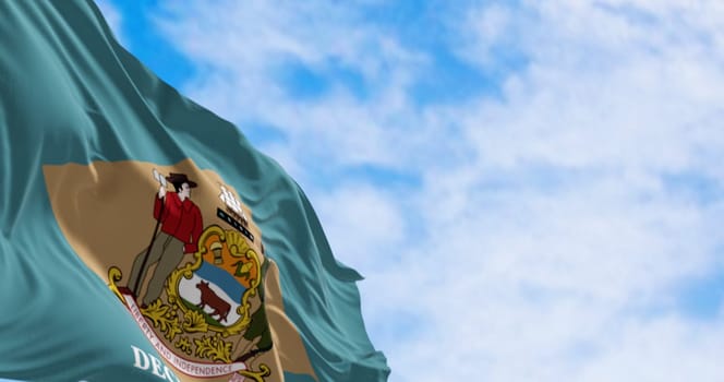 Delaware state flag waving on a clear day. Colonial blue background with a buff-colored diamond and state coat of arms, and December 7, 1787 below it. 3d illustration render. Fluttering fabric