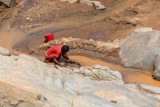 Dabalava, Madagascar - November 1, 2022: Local people mine for gems and pan for gold in a river. If they're lucky, they'll find a little gold flake