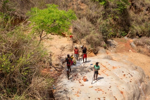 Dabalava, Madagascar - November 1, 2022: Local people mine for gems and pan for gold in a river. If they're lucky, they'll find a little gold flake