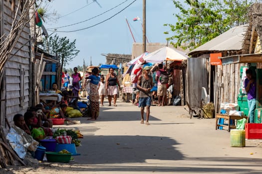 Morondava, Madagascar - November 3, 2022: Locals resting in the shade in front of their markets, their daily life on the street of Morondava, Madagascar.