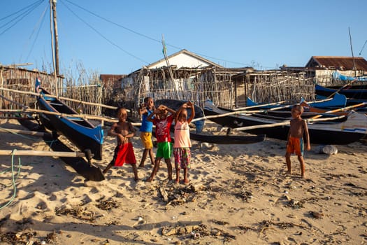 Anakao, Madagascar - November 21. 2022 - Group of Malagasy children frolicking on the beach near the fishing village of Anakao.