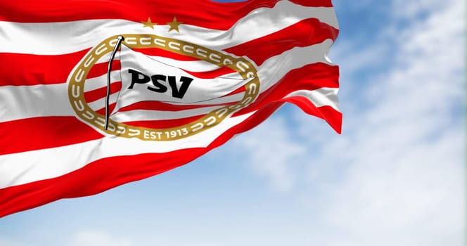 Eindhoven, NL, Sept. 4 2023: PSV Eindhoven football club waving in the wind on a clear day. Dutch sports club from Eindhoven. Illustrative editorial 3d illustration render. Fluttering fabric