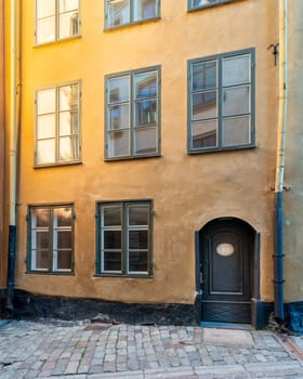 Narrow alley in Gamla stan, the old town of Stockholm, Sweden, with old style orange colored house and cobblestone street, Stockholm, Sweden