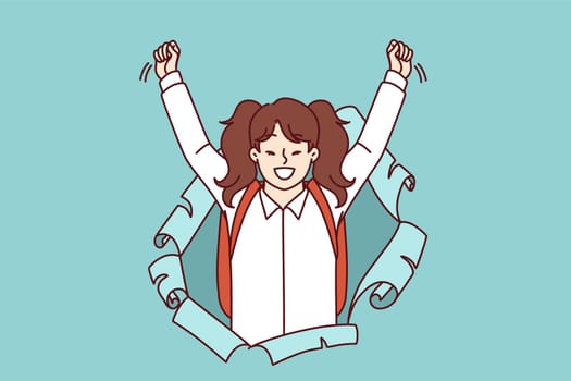 Schoolgirl with backpack joyfully raises hands up and screams loudly peeking out of hole in paper, for concept of back to school. Little girl celebrating beginning of academic year at school