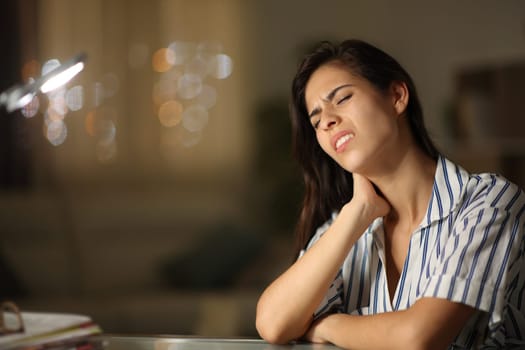 Stressed woman suffering neck ache and complaining sitting in the night at home