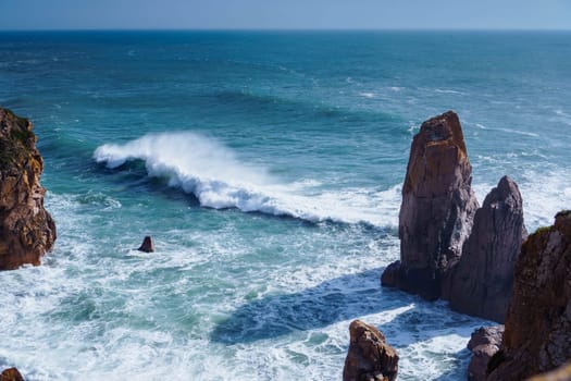Gorgeous view of blue lagoon beach seashore coastline, stormy sea waves surrounded by mountains cliffs on sunny windy day. Summer, holiday, vacation, travelling, seascape, tourism, shoreline, ocean.