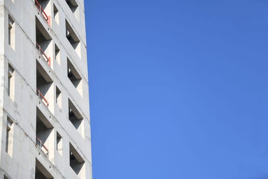 A high-rise building is being built. For fire protection,the stairwell of the office building was made of concrete. The sky as a background is blue.