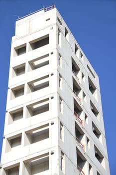 A high-rise building is being built. For fire protection,the stairwell of the office building was made of concrete. The sky is blue.