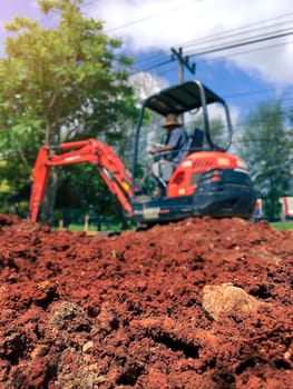Soil close up blurred backhoe to renovate the site in preparation for pouring the concrete slab. Construction concept