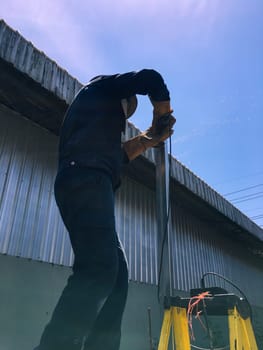 Cutting Metal, Man with cutting steel tool blurred background, Construction concept