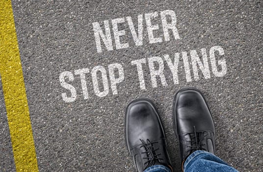 Text on the road - Never stop trying
