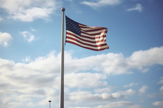 An American flag hanging against a clear sky over a Patriot Day memorial site