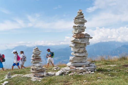 stones piled up by tourists and some hikers on the mountain top of Monte Baldo at Lake Garda near Malcesine in Italy