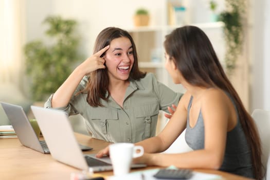 Happy tele worker having idea talking with colleague at home