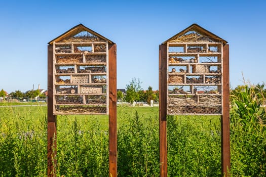 Two wooden bug insect house hotel in a field, bio diversity