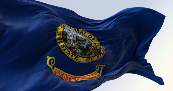 Close-up of the Idaho state flag waving in the wind on a clear day. State seal in a dark blue area with the words "State of Idaho"" in gold letters on a band under the seal. 3d illustration render"